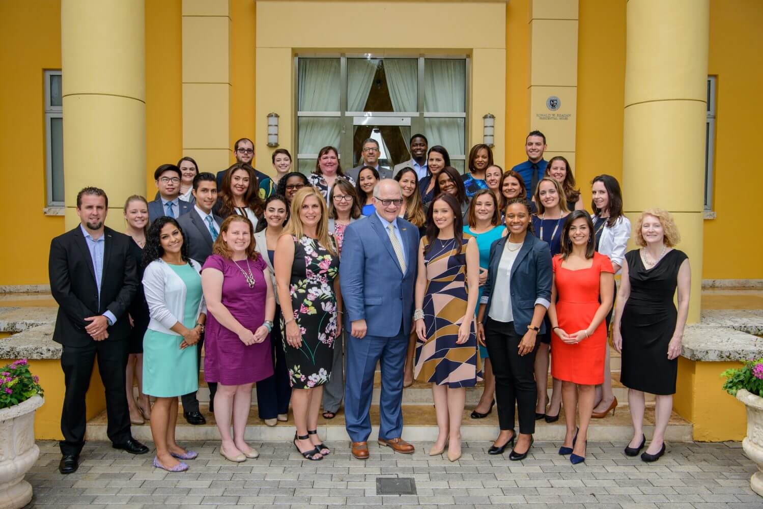 A group photo of cohort #2 of the President's leadership program standing in front of the Ronald W. Reagan Presidential House